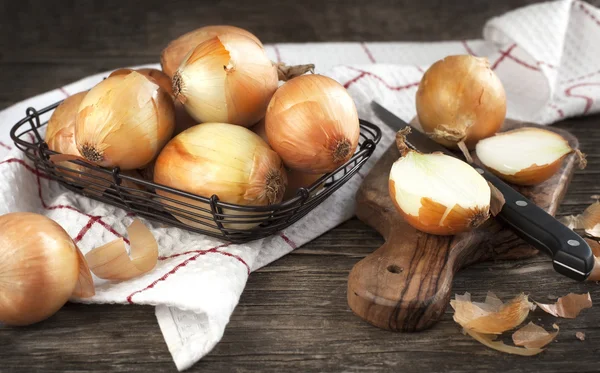 Cut onion on cutting board on wooden background — Stock Photo, Image