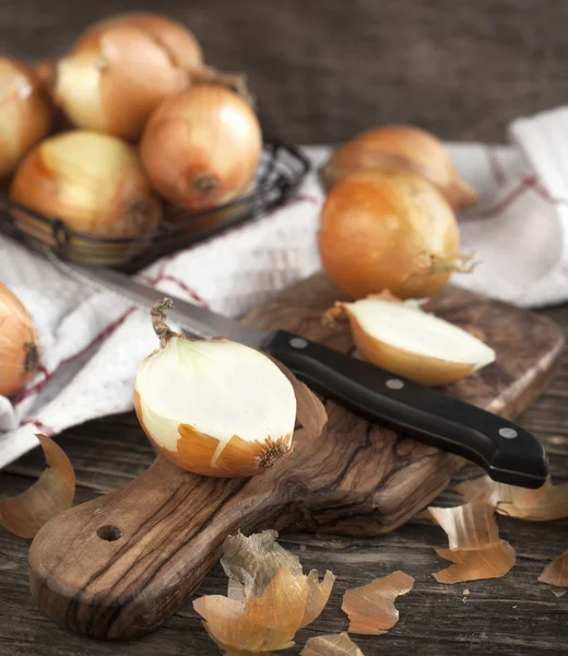 Geschnittene Zwiebel auf Kochbrett auf Holzgrund — Stockfoto