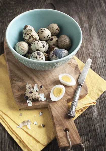 Fresh hard boiled quail eggs with shell beside on cooking board — Stock Photo, Image