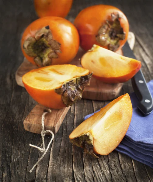 Färsk mogen sharonfrukt på ett träbord — Stockfoto