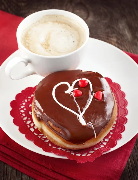 Donut com corações gelados e xícara de café — Fotografia de Stock