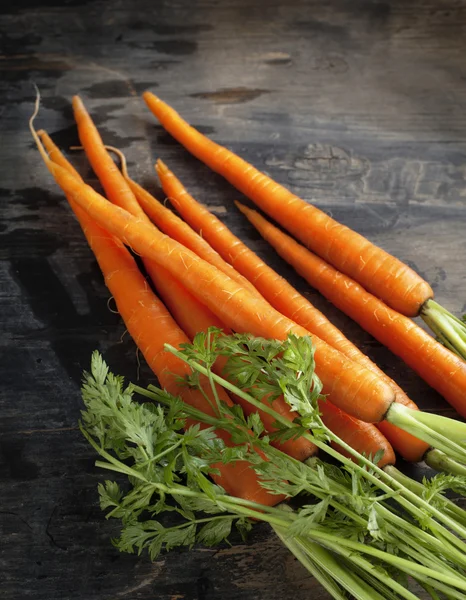 Свежая органическая морковь на темном деревянном фоне — стоковое фото