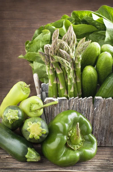 Verse groene groenten op een houten ondergrond. — Stockfoto