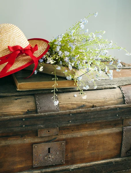 Summer blue flowers and straw hat on old vintage chest — Stock Photo, Image