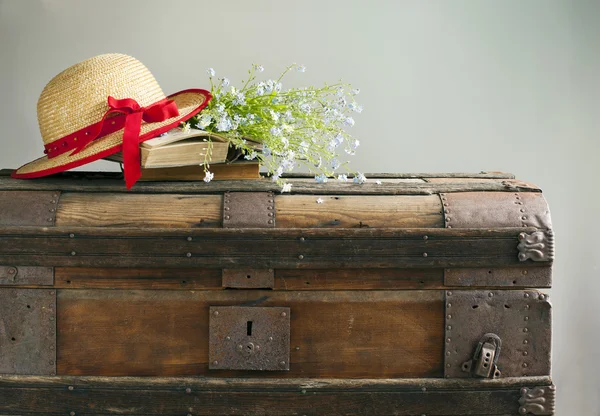 Summer blue flowers, old books and straw hat on old vintage ches — Stock Photo, Image