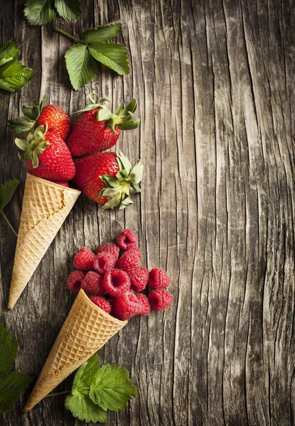 Frambozen en aardbeien in suiker kegels — Stockfoto