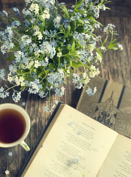 Ramo de flores azules de verano, taza de té y libros antiguos — Foto de Stock