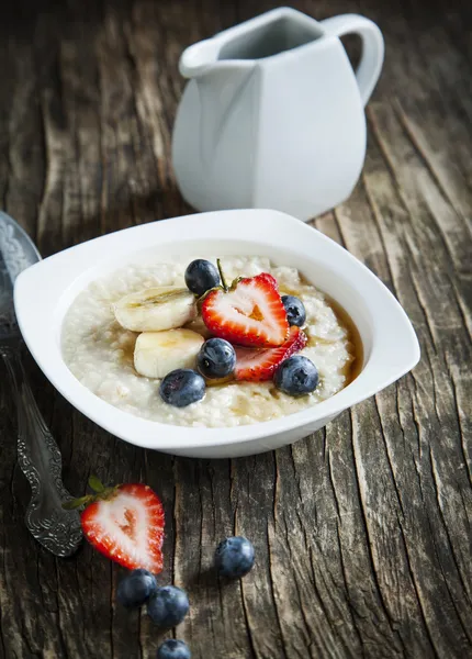 Gesundes Frühstück mit Haferflocken, Ahornsirup und Beeren — Stockfoto