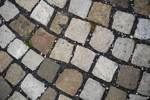 Cobblestone pavement with rocky surface in urban area from directly above. tile top. Close-up of rock block creating structure. Sidewalk in city from rough materials.