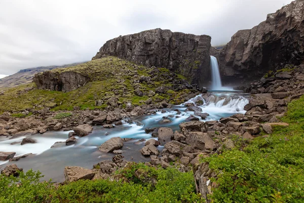 Vodopád Skalnaté Zemi Zelenými Keři Islandu Potok Tekoucí Mezi Skalami — Stock fotografie