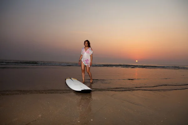 Pretty surf girl on the beach at sunset. — Stock Photo, Image