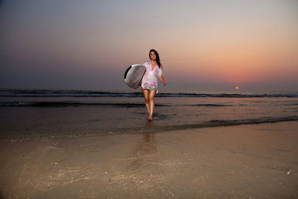 Mooie surf meisje op het strand bij zonsondergang. — Stockfoto