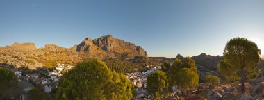 Panoramic photo of stunning mountain landscape with pueblo blanco Montejaque at sunrise. Trees and rocks. Blue sky. Wild. Malaga. Andalusia. Spain. clipart
