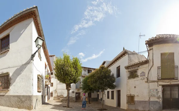 Foto panorámica de una turista de pie en una plaza del barrio del Albaicín, Granada. Andalucía. España. Viejas casas blancas. Cielo nublado azul. Sol. . —  Fotos de Stock