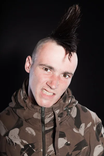 Punk man with mohawk haircut. Expressive face. Army camouflage jacket. Isolated on black background. Studio shot. — Stock Photo, Image