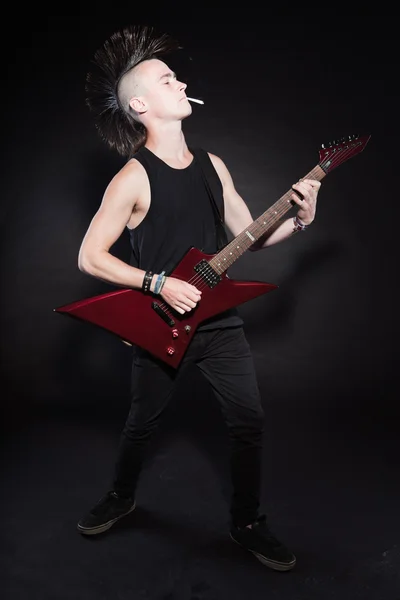 펑크 록 빨간 전기 기타와 모호크 헤어스타일 남자. 표현 적인 얼굴입니다. 검은 배경에 고립. 스튜디오 촬영. — 스톡 사진
