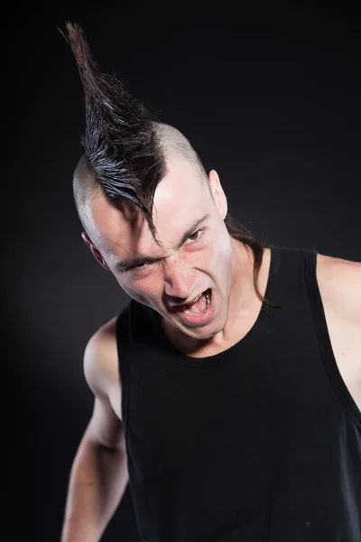 Punk man met mohawk kapsel. zwarte shirt. expressief gezicht. geïsoleerd op zwarte achtergrond. studio opname. — Stockfoto