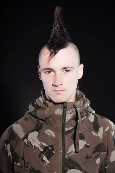 Punk man with mohawk haircut. Expressive face. Army camouflage jacket. Isolated on black background. Studio shot. — Stock Photo, Image