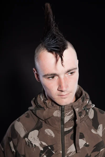 Punk man with mohawk haircut. Expressive face. Army camouflage jacket. Isolated on black background. Studio shot. — Stock Photo, Image