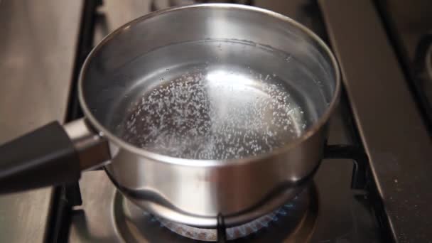 Boiling water on stove in kitchen. High speed movie. — Stock Video