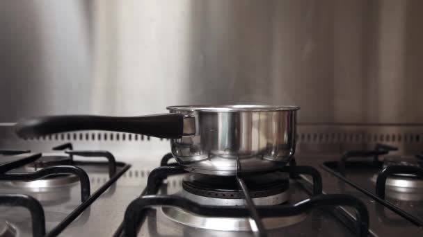 Steam of boiling water on stove in kitchen. — Stock Video