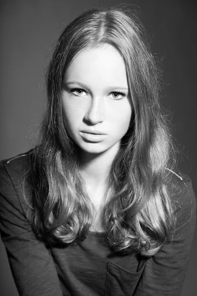 Linda chica joven con el pelo largo y rubio. Retrato de estudio en blanco y negro. Estilo de belleza de moda. Aislado sobre fondo gris . —  Fotos de Stock