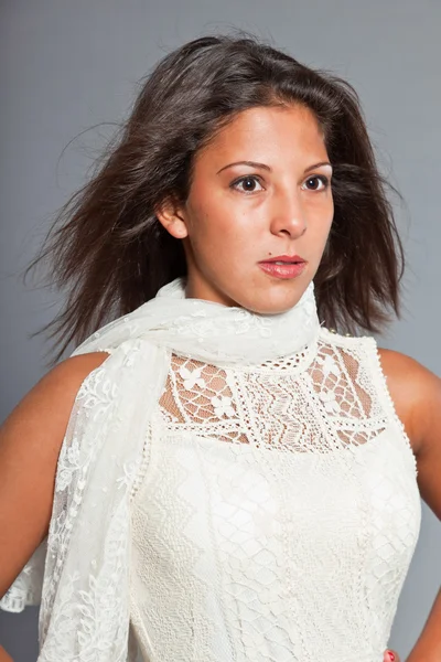 Chica bonita con el pelo castaño y la piel con vestido blanco. Expresión. Muy guapo. Ropa casual. Retrato de estudio aislado sobre fondo gris . — Foto de Stock