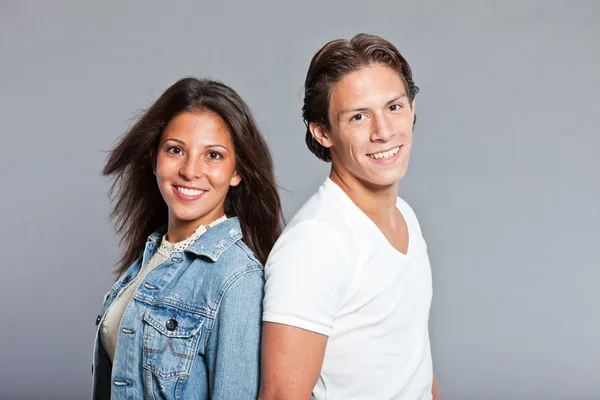 Hübsches junges Paar lässig gekleidet. Bruder und Schwester. gut aussehend. braune Haare und Augen. Studioporträt isoliert auf grauem Hintergrund. — Stockfoto