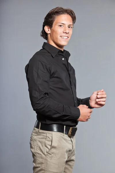 Teenage boy with brown hair and eyes. Wearing black shirt and khaki pants. Good looking. Casual wear. Expressions. Studio portrait isolated on grey background. — Stock Photo, Image