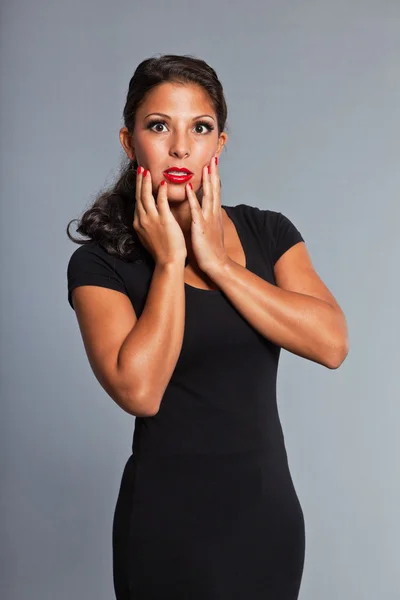 Menina bonita com cabelo castanho e olhos vestindo vestido preto. Batom vermelho e esmalte vermelho. Boa aparência. Gala. Retrato de estúdio isolado sobre fundo cinza . — Fotografia de Stock