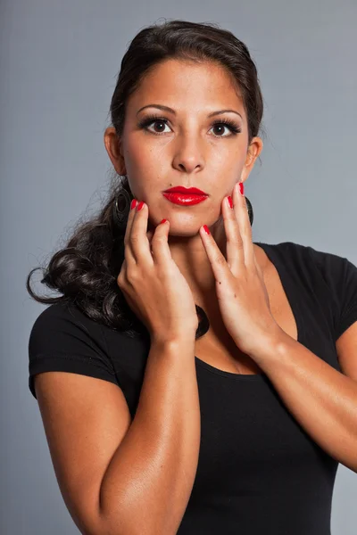 Mooi meisje met bruin haar en ogen dragen zwarte jurk. rode lippenstift en rode nagellak. Knap. Gala. studio portret geïsoleerd op grijze achtergrond. — Stockfoto