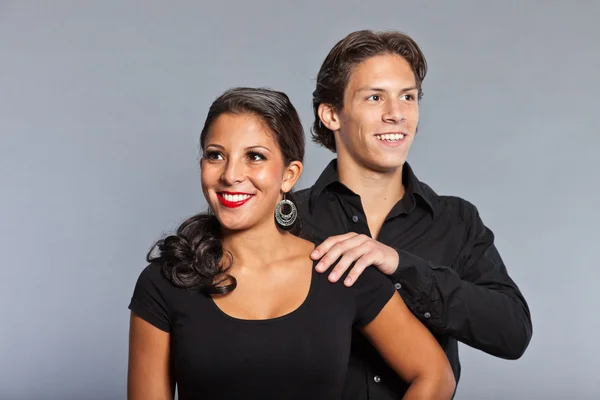 Hübsches junges Paar in schwarz gekleidet. Bruder und Schwester. gut aussehend. braune Haare und Augen. Studioporträt isoliert auf grauem Hintergrund. — Stockfoto