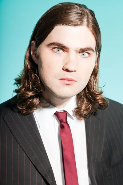 Angry frustrated business man with long brown hair. — Stock Photo, Image