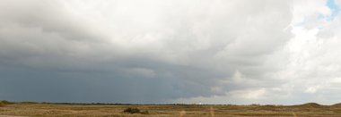 fırtınalı mavi bulutlu gökyüzü ile Hollandalı kumul manzara panoramik çekim.