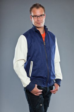 mutlu genç adam kısa saçlı mavi beyzbol ceket ve kot giyen.