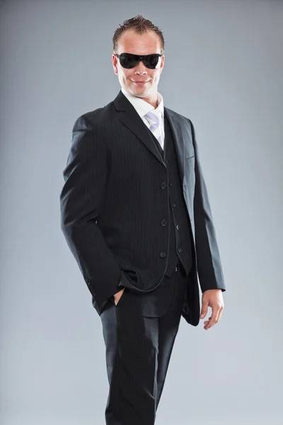 Happy young business man with short hair wearing dark suit with white shirt and purple tie. — Stock Photo, Image