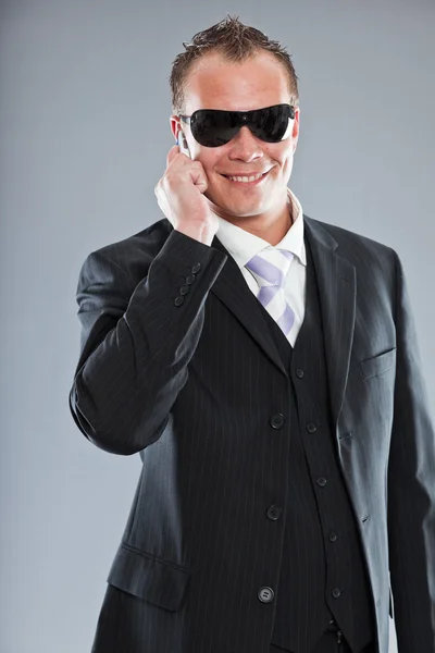Pria bisnis muda yang bahagia dengan rambut pendek mengenakan setelan gelap dengan kemeja putih dan dasi ungu . — Stok Foto