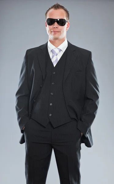 Szczęśliwy młody biznesmen z krótkimi włosami sobie ciemny garnitur, biała koszula i krawat fioletowy. — Zdjęcie stockowe