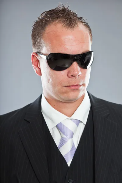 Saldırgan genç iş adamı kısa saçlı beyaz gömlek ve mor kravat ile koyu takım elbise. — Stok fotoğraf
