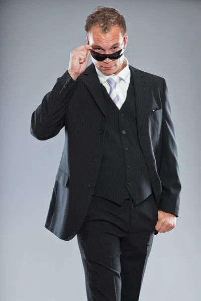 Glücklicher junger Geschäftsmann mit kurzen Haaren trägt dunklen Anzug mit weißem Hemd und lila Krawatte. — Stockfoto