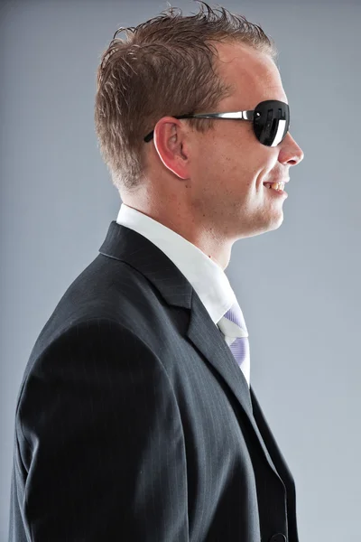 Felice giovane uomo d'affari con i capelli corti indossa abito scuro con camicia bianca e cravatta viola . — Foto Stock