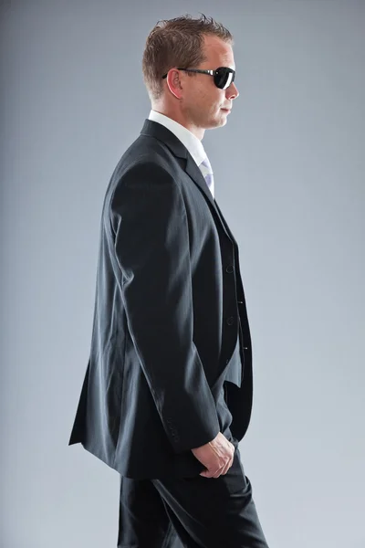 Jovem homem de negócios feliz com cabelo curto vestindo terno escuro com camisa branca e gravata roxa . — Fotografia de Stock