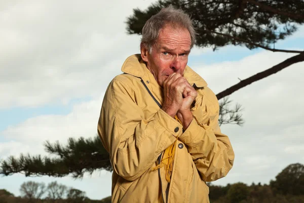 Homme âgé avec un manteau jaune. Avoir froid . — Photo