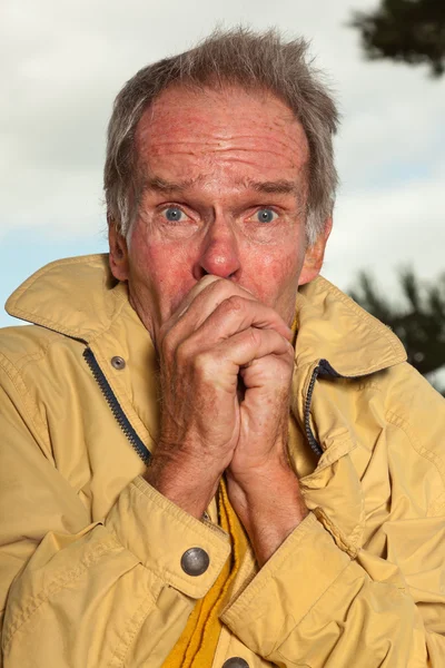 Senior man with yellow coat. Having cold. — Stock Photo, Image