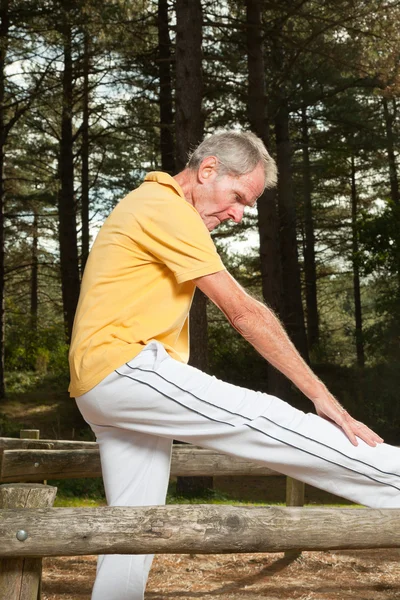 Hombre mayor estirando su pierna . — Foto de Stock