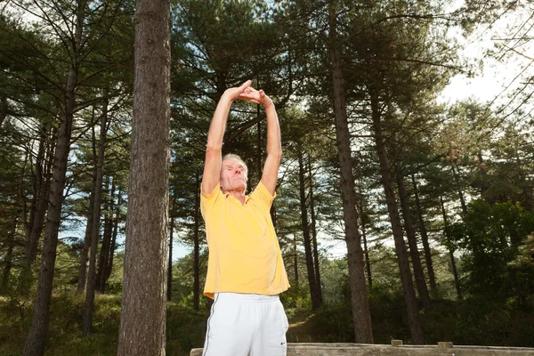 Senior man stretching his arms. — Stock Photo, Image