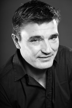 Kısa kahverengi saçlı gülümseyen yakışıklı adam