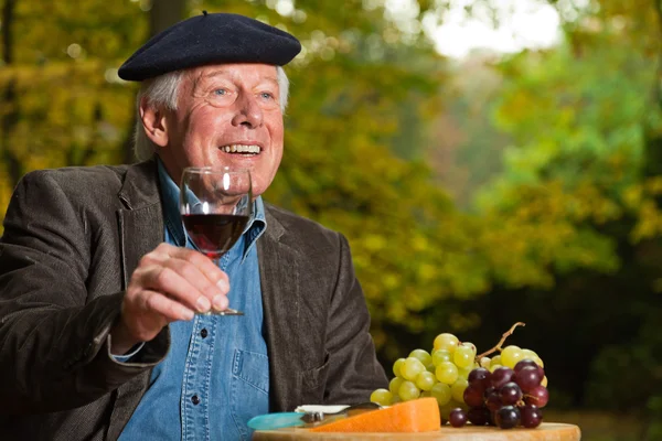 Starszy francuski człowiek korzystających z czerwonego wina. — Zdjęcie stockowe