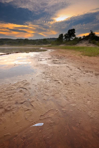 Lago em dunas com pena na areia ao pôr do sol — Fotografia de Stock