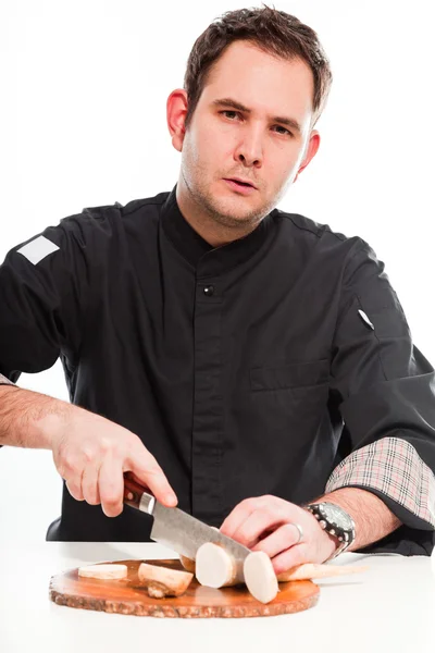 Joven cocinero masculino con chaqueta negra preparando ingredientes crudos . —  Fotos de Stock